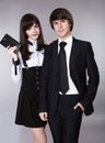 Happy teenagers in school uniform portrait. Handsome boy and beautiful brunette girl posing isolated on studio background. Royalty Free Stock Photo