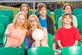 Happy teenagers sitting on the tribune during game Royalty Free Stock Photo