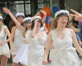 Happy teenagers wearing graduation caps running out from school