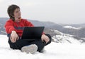 Happy teens with laptop in winter mountains