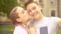 Happy teens taking selfie, looking at camera and kissing, tenderness, memories