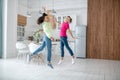 Two girls jumping in the kitchen feeling happy Royalty Free Stock Photo