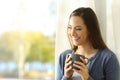 Happy tenant drinking coffee beside a window Royalty Free Stock Photo