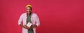 Happy tender handsome African American young man with present, gift in hands wrapped in pink crafted paper smiling Royalty Free Stock Photo