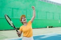 happy tennis player with clenched hand to score with racket