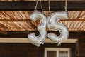 Happy 35th birthday party celebration balloon. Silver number thirty five 35 made of inflatable balloon with golden ribbon isolated Royalty Free Stock Photo