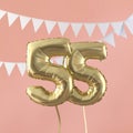Happy 55th birthday party celebration gold balloon and bunting. 3D Render