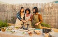 Happy Thai family having fun preparing soup recipe together at house patio