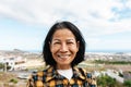 Happy Thai woman having fun having fun smiling into the camera at house rooftop