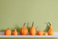 Happy Thanksgiving Background. Selection of various pumpkins on white shelf against green colored wall. Seasonal pumpkins.