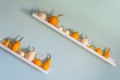 Happy Thanksgiving Background. Selection of various pumpkins on white shelf against pastel turquoise colored wall. Royalty Free Stock Photo