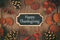 Happy Thanksgiving chalkboard card with autumn leaves over wood Royalty Free Stock Photo