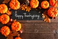 Happy Thanksgiving chalkboard sign with corner border of pumpkins and leaves over rustic wood Royalty Free Stock Photo