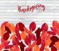 Happy Thanksgiving Day poster.  Background with red and orange fall leaves on wooden board. American traditional november holiday. Royalty Free Stock Photo