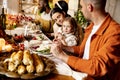 Happy Thanksgiving dinner party with family and friends with turkey and holiday traditional food, dishes on table. Royalty Free Stock Photo