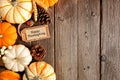 Happy Thanksgiving gift tag with side border of pumpkins and autumn decor over a wood background Royalty Free Stock Photo