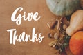 Happy Thanksgiving greeting card. Hand written Give Thanks text on background of pumpkins, autumn leaves, nuts, harvest vegetables Royalty Free Stock Photo