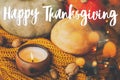 Happy Thanksgiving greeting card. Hand written Happy Thanksgiving text on background of pumpkins, autumn leaves, candle, warm Royalty Free Stock Photo