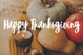 Happy Thanksgiving greeting card. Hand written Happy Thanksgiving text on background of pumpkins, autumn leaves, candle, warm Royalty Free Stock Photo