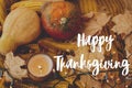 Happy Thanksgiving greeting card. Hand written Happy Thanksgiving text on background of pumpkins, autumn leaves, candle, warm Royalty Free Stock Photo