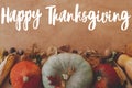 Happy Thanksgiving greeting card. Hand written Happy Thanksgiving text on background of pumpkins, autumn leaves, nuts, harvest Royalty Free Stock Photo