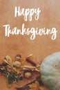 Happy Thanksgiving greeting card. Hand written Happy Thanksgiving text on background of pumpkins, autumn leaves, nuts, harvest Royalty Free Stock Photo