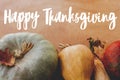 Happy Thanksgiving greeting card. Hand written Happy Thanksgiving text on background of pumpkins, autumn leaves, nuts, harvest Royalty Free Stock Photo