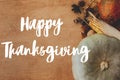 Happy Thanksgiving greeting card. Hand written Happy Thanksgiving text on background of pumpkins, autumn leaves, nuts, harvest Royalty Free Stock Photo