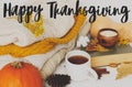 Happy Thanksgiving greeting card. Happy Thanksgiving text handwritten on warm tea, pumpkins, cozy knitted sweaters, autumn leaves Royalty Free Stock Photo