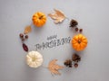 Happy Thanksgiving greeting message with autumn pumpkins and leaves over textured gray background Royalty Free Stock Photo