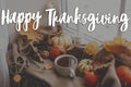 Happy Thanksgiving! Happy thanksgiving text and warm cup of tea, pumpkins, fall leaves, candle on cozy scarf. Season Greeting Royalty Free Stock Photo