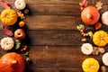 Happy Thanksgiving holiday background. Flat lay, top view pumpkins, apple, red berries, fall leaves, walnuts on wooden desk table Royalty Free Stock Photo