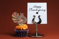 Happy Thanksgiving message with orange cupcake with turkey decoration. Royalty Free Stock Photo