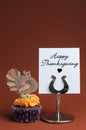 Happy Thanksgiving message with orange cupcake with turkey decoration - vertical. Royalty Free Stock Photo