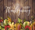 Happy Thanksgiving poster with autumn leaves on wood background. Vector illustration.