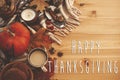 Happy Thanksgiving text on autumn flat lay with pumpkin,coffee,candle,fall leaves, cookies,berries,nuts,acorns on rustic blanket Royalty Free Stock Photo