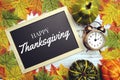 Happy Thanksgiving text on blackboard decorate with maple leaves and pumpkin on wooden background