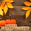 Happy Thanksgiving wooden blocks with wood background, leaves and pumpkins Royalty Free Stock Photo