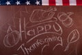 Happy Thanksgiving, written in white chalk on a blackboard,