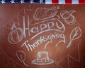 Happy Thanksgiving, written in white chalk on a blackboard,