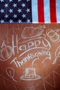 Happy Thanksgiving, written in white chalk on a blackboard,