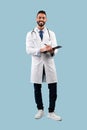 Happy Therapist Doctor Making Medical Record Standing Over Blue Background Royalty Free Stock Photo
