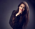 Happy thinking beautiful woman with long hair style in black shirt looking with toothy smiling on dark shadow background. Closeup