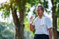 Happy thirsty senior man drinking fresh water after sports in park, Concept of senior healthy lifestyle