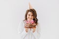 a happy thirty-year-old woman with a birthday cake with candles.