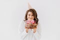 a happy thirty-year-old woman with a birthday cake with candles.