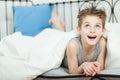 Happy Thoughtful Boy Lying on his Bed with Blanket