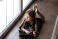 Happy thoughtful gen Z child resting on heating floor Royalty Free Stock Photo