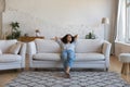 Happy thoughtful Latin woman resting on comfortable couch at home Royalty Free Stock Photo