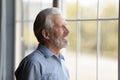 Happy thoughtful older 70s man looking out of window Royalty Free Stock Photo